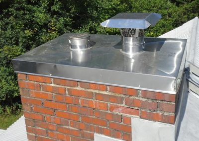 Stainless steel chimney cap on red brick chimney