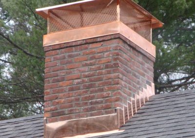 Copper chimney cap with copper flashing and black roof
