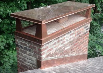 chimney cap on top of brick chimney