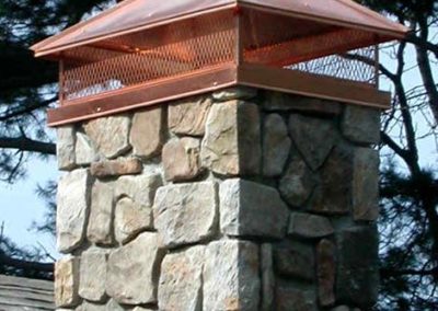 Copper chimney cap with a stone chimney