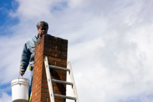 Suffolk County, NY Chimney Sweep & Inspection - Alpine Chimney man on ladder with bucket next to chimney